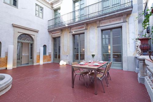 mesa y sillas en el patio de un edificio en Ola Living Portaferrissa, en Barcelona