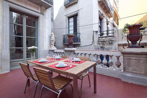 een houten tafel en stoelen op een patio bij Ola Living Portaferrissa in Barcelona