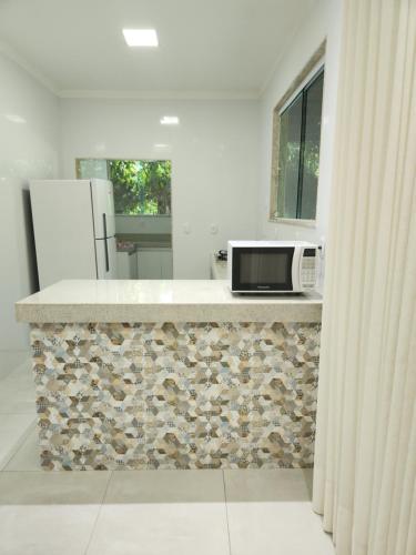 una cocina con encimera y microondas. en Villa Gardem, en Aracaju