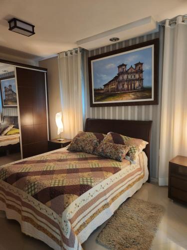 1 dormitorio con 1 cama con una foto en la pared en Villa Gardem, en Aracaju