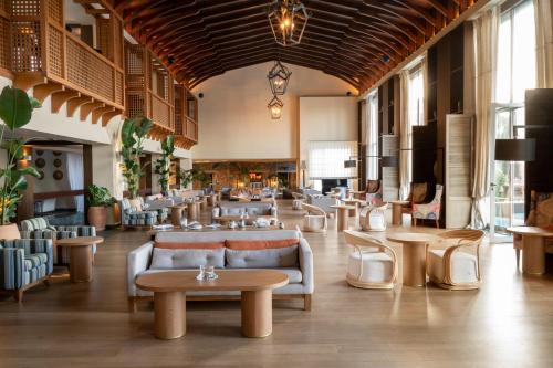 a lobby with couches and tables in a building at Aquila Elounda Village Resort, Suites & Spa in Elounda