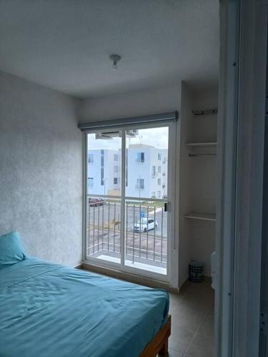 a bedroom with a bed and a large window at Departamento en CanCun. in Cancún