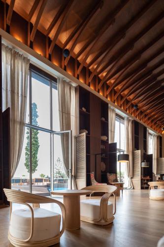 a room with two chairs and a table and a large window at Aquila Elounda Village Resort, Suites & Spa in Elounda