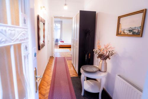 a narrow hallway with a table and a room at Apartment Charles in Budapest