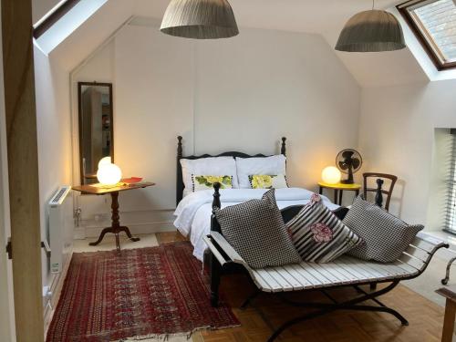 ein Schlafzimmer mit einem Bett mit zwei Stühlen und zwei Lampen in der Unterkunft The Sheep Loft in Lincolnshire