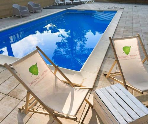 two lawn chairs sitting next to a swimming pool at 3 WIOSŁA Brzozowa Zatoka in Brenno