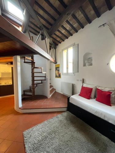 Un dormitorio con una cama con almohadas rojas y una escalera en Il Mini, en Imola