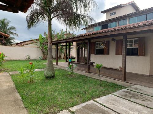 ein Haus mit einer Palme im Hof in der Unterkunft Recanto do Peixe Dourado in Casimiro de Abreu
