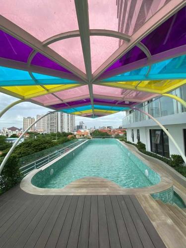 a swimming pool under a colorful umbrella on a building at Morgan enmaison in Phnom Penh