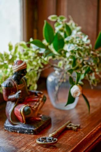 une table en bois avec un vase de fleurs et une figurine dans l'établissement Château de Thouaré, à Thouaré-sur-Loire
