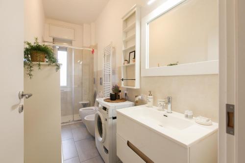 Splendido Bilocale sul Naviglio Grande في كورسيكو: حمام أبيض مع حوض ومرحاض