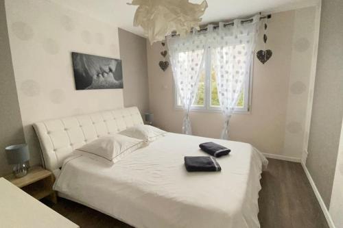 une chambre avec un lit blanc et une fenêtre dans l'établissement Ty inizi : Maison avec piscine, à Kerlouan