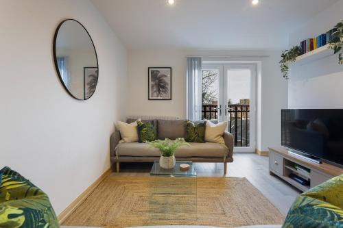 a living room with a couch and a mirror at Large, newly renovated, three bedroom TOWN CENTRE split level apartment with free parking, sleeps seven - Walking distance to beach in Bournemouth