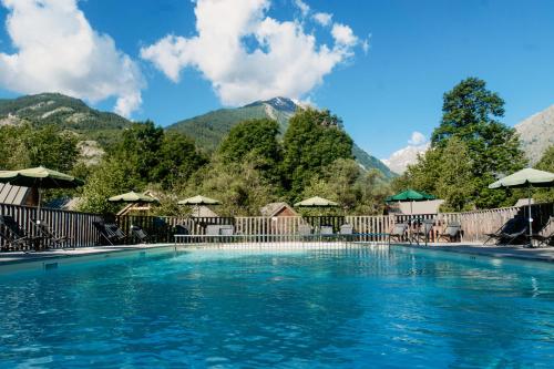 een zwembad met bergen op de achtergrond bij Huttopia Vallouise in Vallouise