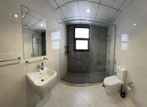 La salle de bains est pourvue d'un lavabo, de toilettes et d'une douche. dans l'établissement Sea Breeze Villa, à Fujaïrah