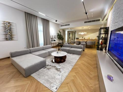 a living room with a couch and a tv at Sea Breeze Villa in Fujairah