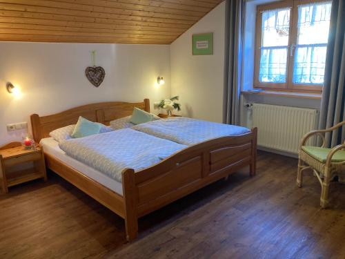 a bedroom with a large wooden bed with blue sheets at Haus Petra und Toni Holzheu in Bad Hindelang