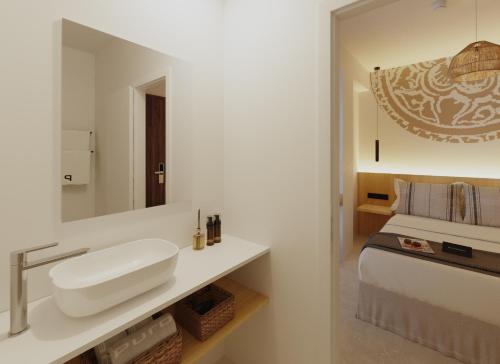 a white bathroom with a sink and a bed at Sauló By Puro in Can Pastilla