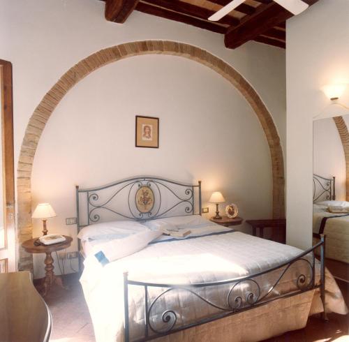ein Schlafzimmer mit einem Bett mit einem Bogen darüber in der Unterkunft Villa Panconesi in Montespertoli