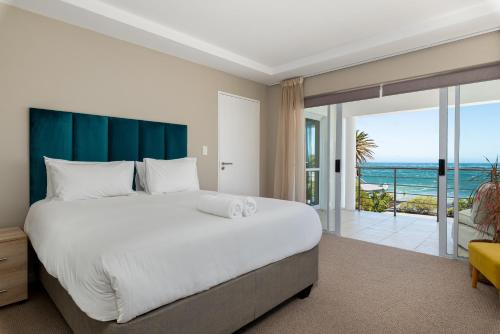 a bedroom with a large bed and a view of the ocean at 58 Kreef Lane in Cape Town