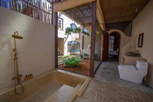 a bathroom with a bath tub and a toilet at Red Sands Pool Villa in Phan Thiet