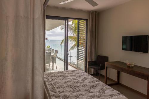 - une chambre avec un lit et un balcon donnant sur l'océan dans l'établissement Beautiful 3 bed-room beachfront penthouse, à Grand Baie