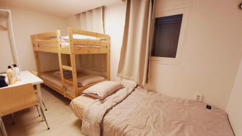 - une chambre avec des lits superposés et un bureau avec une fenêtre dans l'établissement G Yongsan Inn, à Séoul