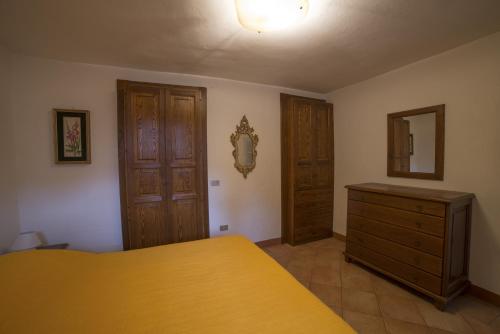 a bedroom with a yellow bed and a wooden cabinet at Appartamento Olga in Stresa