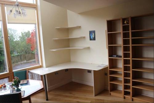 a room with a desk and shelves and a window at Stylish 1 Bedroom Flat in the heart of St Andrew's in Bristol