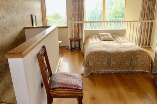a bedroom with a bed and a chair at Stylish 1 Bedroom Flat in the heart of St Andrew's in Bristol