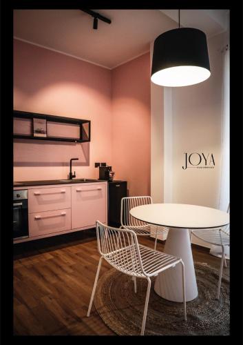 a room with a table and chairs and a kitchen at Joya Apartment's - Milazzo in Milazzo