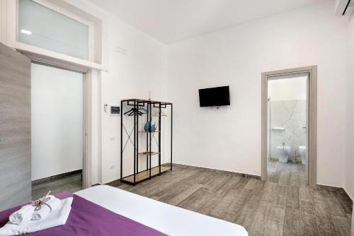 a bedroom with a bed and a tv on a wall at Appartamento Al Corso in Salerno