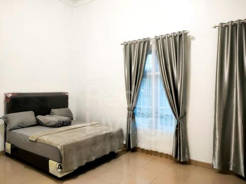 - une chambre avec un lit et une fenêtre avec des rideaux dans l'établissement Guest House Syariah Bunga Intan RedPartner, à Metro