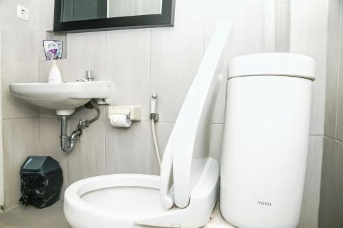 a bathroom with a white toilet and a sink at Istanaku Guesthouse 2 in Manado