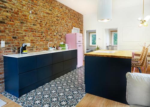 una cucina con muro di mattoni e frigorifero rosa di Apartament na Wzgórzu a Kudowa-Zdrój