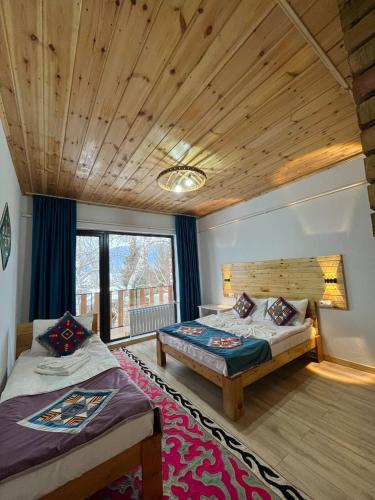 a bedroom with two beds and a large window at Guest House Jekshen in Imeni Karla Marksa