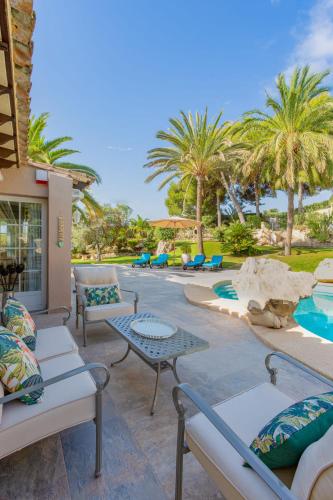 a patio with tables and chairs and a pool at Azzurra Home-Charming Property- For 6 guests in Benissa