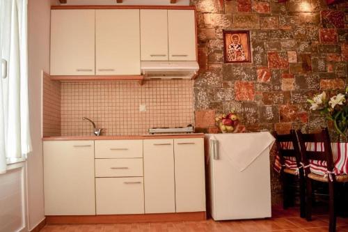 een keuken met witte kasten en een witte koelkast bij Meltemi Beach Apartments 2 in Milatos