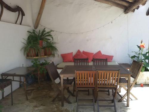 a dining room with red pillows on a table at La Carrihuela Amarilla in Algodonales