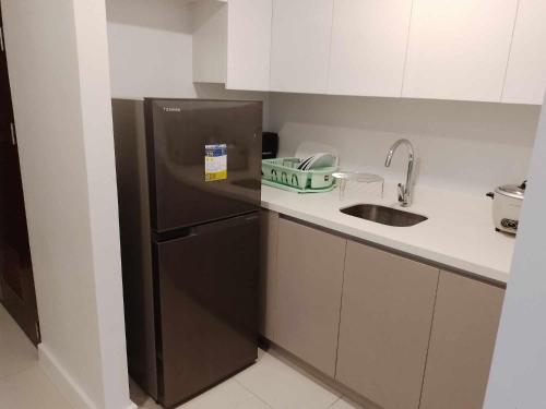 a kitchen with a black refrigerator and a sink at 38 Park Avenue condominium, IT Park in Cebu City