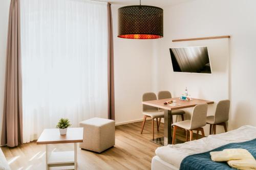 a room with a table and chairs and a bed at Hotel Zur Seemöwe in Kirchdorf