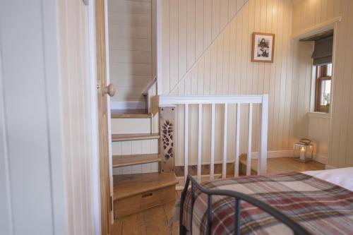 The Wee House في Pennan: غرفة نوم بها درج وسرير في غرفة