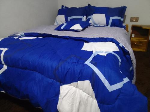 eine blaue und weiße Bettdecke auf einem Bett in der Unterkunft Mixtech Vacation Home -MVH in Sunyani