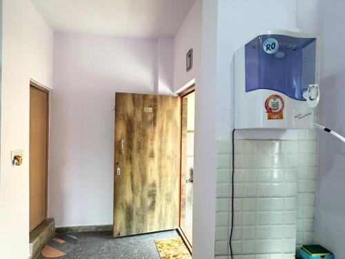 een badkamer met een houten deur en een douche bij Amazing AC Studio in E City 3F 301 in Bangalore