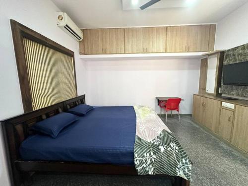 een slaapkamer met een bed, een tafel en een televisie bij Amazing AC Studio in E City 3F 301 in Bangalore