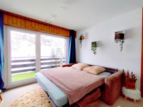 a bedroom with a bed and a large window at ''Chalet'' au Centre et Parking Couvert GRATUIT in Veysonnaz