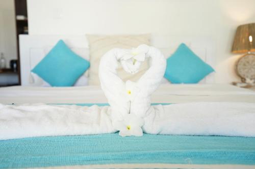 a towel sculpture of two swans on a bed at Sukacita Hill in Uluwatu