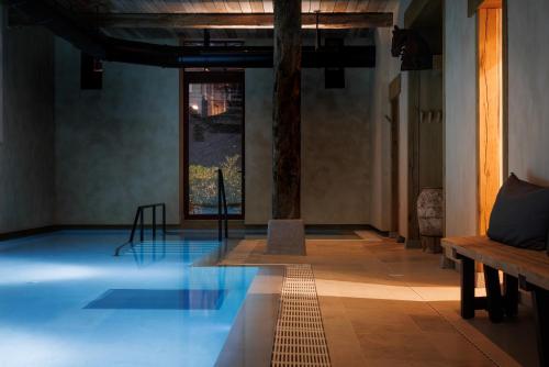 a pool in a room with a table and a bench at Domaine de Locguénolé & Spa - Relais & Chateaux in Kervignac