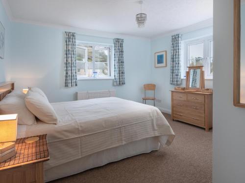 希望海灣的住宿－New Cottage，卧室配有白色的床和2扇窗户。