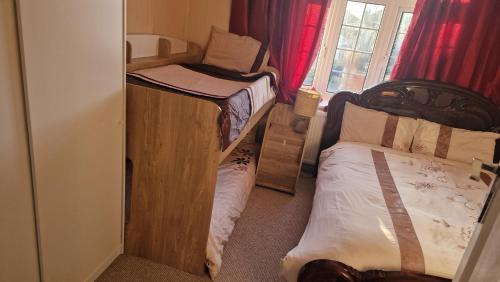 a small room with two bunk beds and a window at Family home three bed house near the beach in Herne Bay